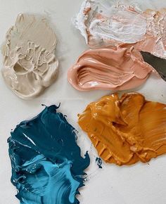 four different colors of paint sitting on top of each other