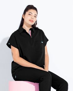 Modern, and sleek featuring a collared detail, our Capri top offers a looser fit. With a front chest pocket and 2 side pockets, it's safe to say our Capri top is the perfect combination of style and functionality. - Oversized fit - Modern collar style - Total of three pockets ✓ One front chest pocket ✓ Two side-angled pockets - Draped shoulder design Sporty Short Sleeve Tops With Pockets, Black Workwear Tops With Pockets, Athleisure Relaxed Fit Collared Tops, Black Tops With Collar And Pockets, Collared Athleisure Tops With Relaxed Fit, Black Tops With Pockets And Collar, Relaxed Fit Collared Tops For Athleisure, Relaxed Fit Collared Tops In Athleisure Style, Collared Tops With Pockets For Work