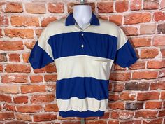 "vintage 70s/80s huk a poo polo shirt with banded waist, blue stripes, and textured white sections. Lightly used no major Flaws to note MEASURES -  19.5\" pit to pit and 26\" long TAGGED - M ~ BE SURE TO CHECK OUT MY ENTIRE SHOP ~ - This is a TRUE VINTAGE item! Vintage clothing sizing varies wildly ALWAYS use the measurements and info provided in the listing to assure proper fit! Unless the words \"deadstock\" or \"unworn\" are used please understand this is a USED item. RETURNS - My policy is N Vintage Summer Polo Collar T-shirt, Striped Polo Shirt With Ribbed Collar For Summer, Vintage Polo Collar T-shirt For Summer, Vintage Summer Polo T-shirt, Vintage Summer T-shirt With Polo Collar, Retro Cotton Polo Shirt For Summer, Retro Summer Polo Shirt With Polo Collar, Retro Fitted Collared Polo Shirt, Retro Polo Shirt With Relaxed Fit