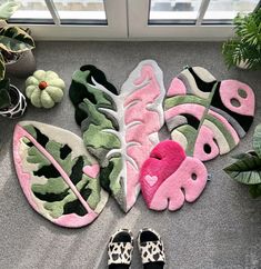 several pairs of slippers sitting on the floor next to plants and potted plants