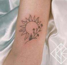 a small sunflower tattoo on the arm