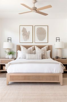 a bedroom with a bed, two lamps and pictures on the wall