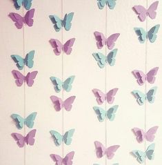 there are many butterflies hanging on the wall and one is blue with purple in it