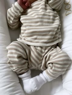 a baby laying on top of a white pillow