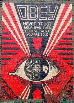 an advertisement on the side of a building that says, obey never trust your own eyes believe what you are told