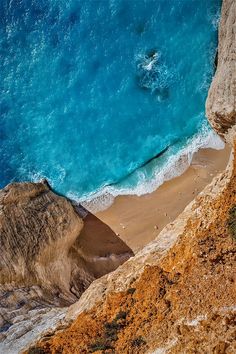 an aerial view of the beach and ocean from high up on a cliff overlooking the water