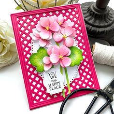 a close up of a card with flowers on it and scissors next to the card