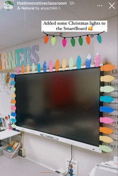 a flat screen tv mounted to the side of a wall next to a bulletin board