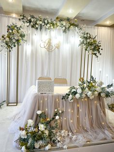 the table is set up with flowers and greenery on it for an elegant wedding