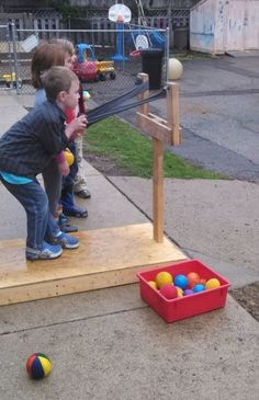 two children playing with balls on the sidewalk