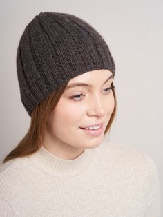 a woman wearing a gray hat and smiling