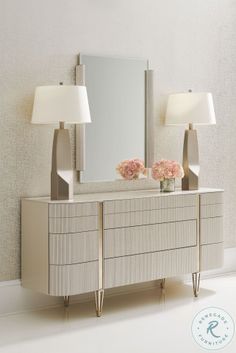 a white dresser with two lamps and a mirror on the wall next to each other