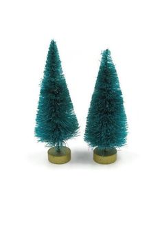 two small green trees sitting on top of each other in front of a white background