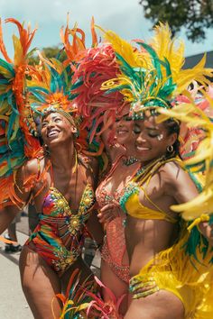 three women in colorful costumes are posing for the camera