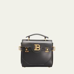 Balmain "BBuzz 23" smooth calf leather satchel crossbody bag Flat, slim top handle anchored by metal bars Detachable, adjustable crossbody strap Flap top with logo B hardware; turn-lock closure Belted exterior secures at tab front Exterior, back slip pocket  Interior, one zip pocket and one card slot  Feet protect bottom of bag  Approx. 7.8"H x 9"W x 4.3"D Made in Italy Business Satchel With Logo Hardware And Top Handle, Modern Satchel With Logo Hardware For Formal Use, Modern Satchel With Logo Hardware For Formal Occasions, Formal Top Handle Satchel With Logo Hardware, Modern Formal Satchel With Logo Hardware, Luxury Satchel With Logo Hardware, Luxury Rectangular Satchel With Logo Hardware, Luxury Formal Satchel With Logo Hardware, Luxury Top Handle Shoulder Bag With Logo Hardware