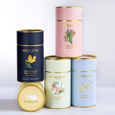 four different types of tea tins sitting next to each other on a white surface