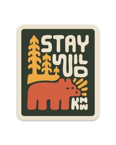 a sticker with the words stay wild and an orange bear in front of trees