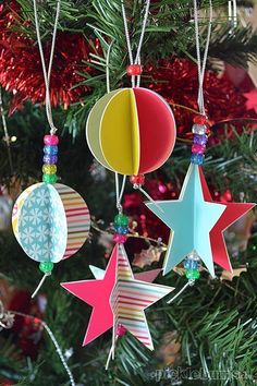 paper stars hanging from a christmas tree with scissors and other crafting supplies in the background