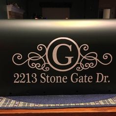 a black sign with the letter g on it that says, 213 stone gate dr