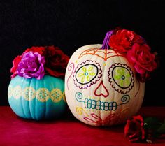 two painted pumpkins with flowers on them and the words scary - chic no - carve day of the dead pumpkins