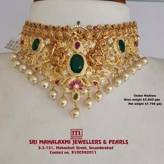 the necklace is adorned with pearls and green stones