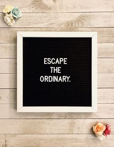 a black and white frame with the words escape the ordinary on it next to flowers