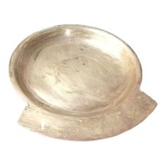 a silver plate sitting on top of a white surface