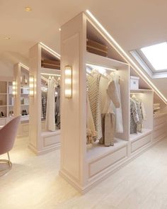 a room filled with lots of white furniture and shelves full of clothes on hangers