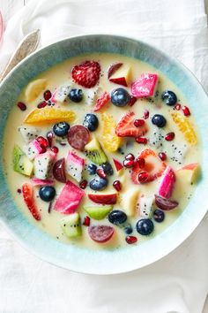 a bowl filled with fruit and yogurt on top of a white table cloth