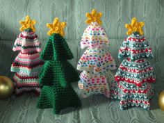 crocheted christmas trees lined up on a couch