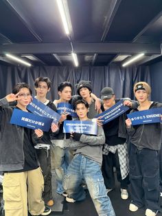 a group of young men holding up signs in front of their faces and posing for the camera