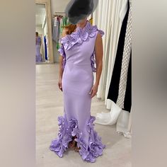 a woman in a purple dress standing next to a mannequin