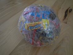 a plastic bag filled with toys on top of a wooden floor