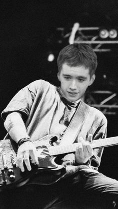 a young man playing an electric guitar on stage