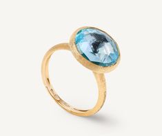 Boasting bright colors and clean lines, this ring is embellished by a carefully selected semi-precious gemstone, encircled in an 18K yellow gold bezel setting, hand-engraved using an ancient Florentine technique. It is perfect on its own or matched with the other colors in the collection. Sara Sampaio, London Blue Topaz Ring, Branded Gifts, Blue Topaz Ring, London Blue Topaz, London Blue, Topaz Ring, High Jewelry, Handmade Design