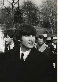 black and white photograph of young man in suit with others behind him, possibly from the 1960s's