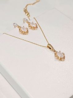 High quality champagne gold plated crystal earrings and necklace set with beautiful frosted white cubic zirconia stones. The chain is 1mm thick and 46cm long. It is easily adjustable to make it shorter to your desired length simply by pulling on the chain through the round gold bead. It also has 2 removal options - using the clasp or pulling the chain out of the round gold bead as shown in the pictures. There are 2 jewelry box options: Box A: regular jewelry cardboard box with a textured diamond pattern on the outside (comes in white, black or red) Box B: Velvet earring and necklace box (comes in green, red and grey) You can also add a mini gift bag as show in the pics: comes with green, red or grey satin ribbon and a few sheets of gift tissue paper. Ready to ship in 1-3 business days Come Elegant Jewelry With Matching Earrings And Oval Pendant, Oval Crystal Earrings Gift, Oval Crystal Earrings For Gifts, Gold Oval Jewelry Set For Wedding, Oval Gold Jewelry Set For Wedding, Elegant Oval Jewelry Sets As Gifts, Elegant Oval Jewelry Set For Gift, Oval Pendant Jewelry Set As Gift, Gatsby Earrings