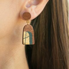 These handcrafted wooden earrings made from mahogany wood elegantly combine natural beauty with a striking design. 🌻 Adorned with gold and green details, these unique artistic earrings offer a stylish, aesthetic, and eye-catching look for those who love bohemian style. 🌿 Ideal for daily wear and special occasions, these showy earrings can be a meaningful and unique gift for your loved ones on Valentine's Day or Christmas. 🌾 With their natural touches and bohemian spirit, you can be sure they Wooden Earrings For Gift, Artisan Brown Wooden Earrings, Artisan Brown Wood Earrings, Brown Wooden Earrings As Gift, Unique Brown Wooden Earrings, Brown Wooden Bead Earrings As A Gift, Unique Natural Wood Earrings, Brown Earrings With Wooden Beads As Gift, Wooden Jewelry With Matching Earrings As Gift