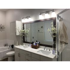 a bathroom with two sinks and a large mirror above the sink is decorated with flowers