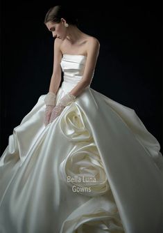 a woman in a white wedding dress is posing for the camera with her hands on her hips