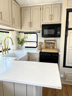 a kitchen with white counter tops and black appliances