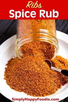 a jar filled with spices sitting on top of a white plate next to a spoon