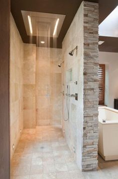 a walk in shower sitting next to a white tub