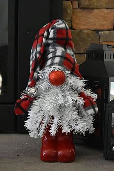 a white christmas tree with red and black plaid on it, sitting in front of a fire hydrant