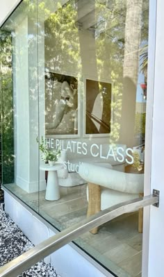 there is a glass window that says the pilates class studio in front of it