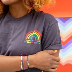 a woman with red curly hair wearing a rainbow bracelet