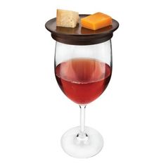 a wine glass filled with red wine and cheese