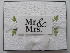 a wedding card with the word mr and mrs on it, decorated with white flowers