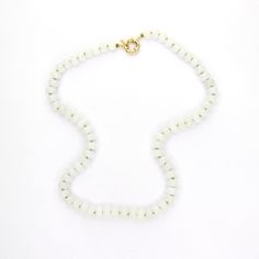 This 18.5" necklace features hand-knotted white Jade gemstones strung with lime green silk thread. Finished with a gold-filled clasp, it offers the versatility of adding charms for a personalized touch and looks great layered or worn alone. White Jade is believed to promote love, luck, and peace. Everyday White Single Strand Necklace, Minimalist White Gemstone Beaded Necklaces, White Minimalist Beaded Gemstone Necklace, Everyday White Single Strand Beaded Necklace, White Faceted Everyday Jewelry, Everyday White Faceted Beaded Necklace, White Hand-strung Rondelle Necklace, Everyday White Faceted Jewelry, White Single Strand Jade Jewelry