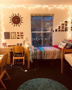 a bedroom with lights strung from the ceiling and a bed in front of a window